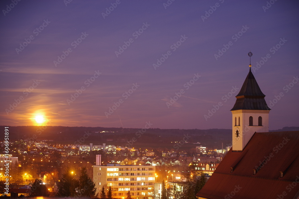 Naklejka premium City at night with a large clock tower in the background