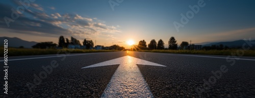 White arrow on a road at sunrise