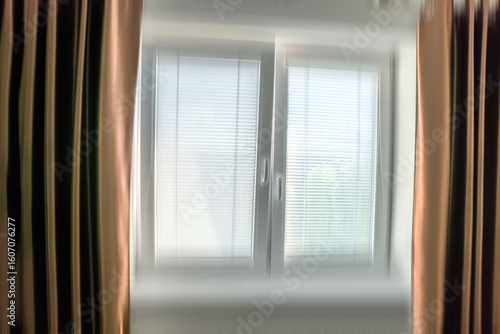 Blurry closed  window in the room. Brown Drapes on the sides