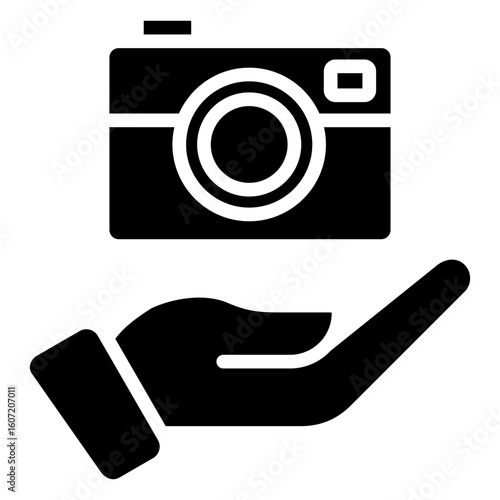 Camera Service Glyph Black Silhouette Icon Vector Design - Camera held in hand, symbolizing photo service, digital asset offering, or photography support