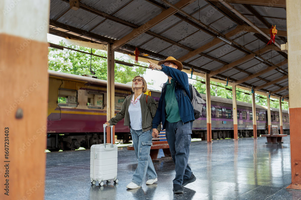Fototapeta premium Happy Asian senior boarding a train at the station