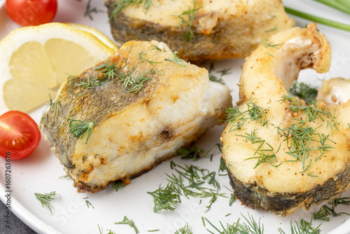 Obraz na plátně Baked zander fish with lemon, dill and cherry tomato on white ceramic plate closeup