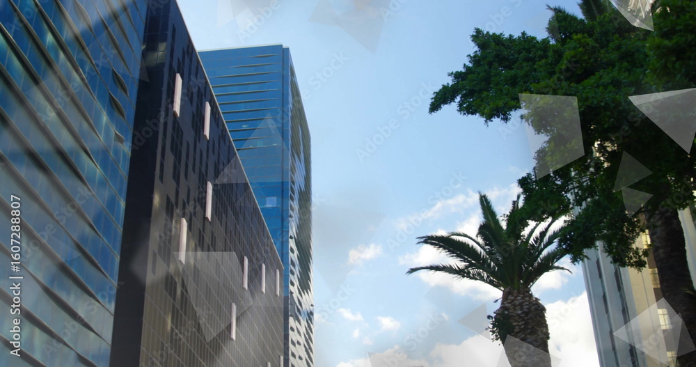 Fototapeta premium Rising glass-clad skyscrapers in downtown, palm tree, leafy tree, clouds, reflections, copy space