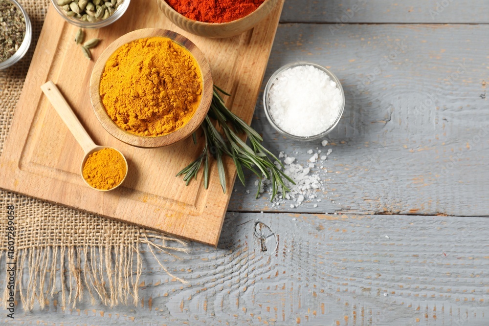 Different aromatic spices on grey wooden table, flat lay. Space for text Different aromatic spices on grey wooden table, flat lay. Space for text