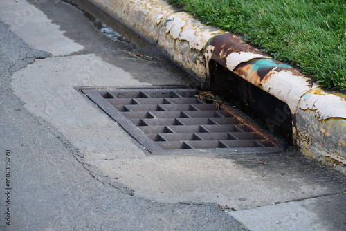 Storm drain in roadway. Old and mis colored materials.