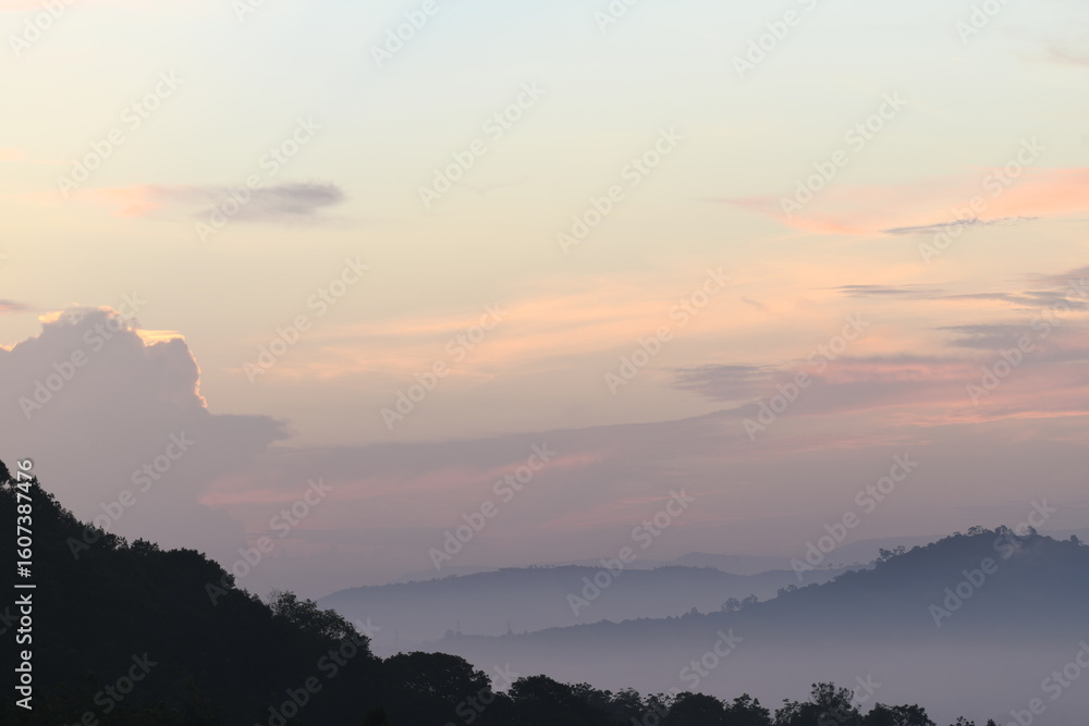 Fototapeta premium A tranquil mountain range landscape with a mesmerizing dusk sky. The silhouette of the mountains creates a sense of serenity