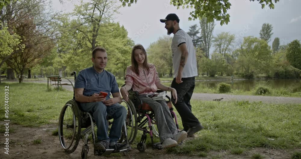Two cheerful young people in wheelchairs alongside a photographer capture a moment of joy and friendship in an inclusive park setting by the lake. Two cheerful young people in wheelchairs alongside a photographer capture a moment of joy and friendship in an inclusive park setting by the lake.