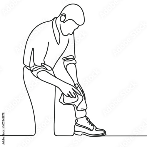 Man sitting, tying shoe against blank background