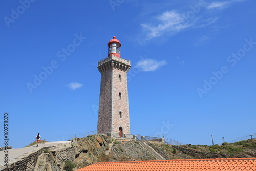 Person walking towards Phare du Cap Béar, a lighthouse on Mediterranean sea coast near Port-Vendres in Pyrénées-Orientales department, France