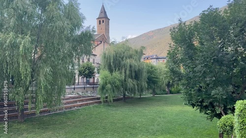 Church tower and willow trees in peaceful park

