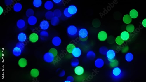 Abstract Blue and Green Bokeh Lights on a Black Background Creates a Festive and Magical Ambiance with Blurry and Circular Light Effects