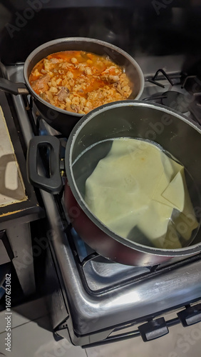 Lasagna pasta sheet, boiling water, and heating red pozole. Preparing lasagna for Christmas dinner.
