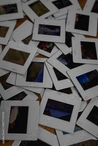 Old photo slides laying on a wooden table showing different pictures capturing memories