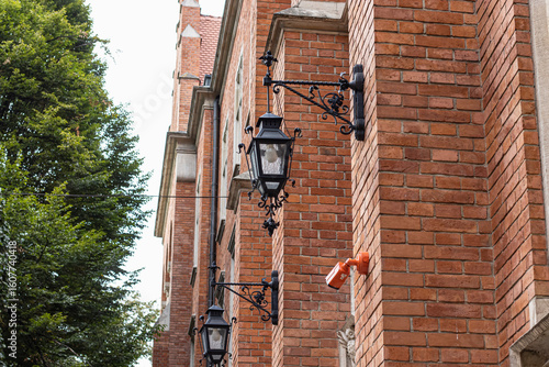 Ornate Street Lamps and Red Brick Wall on a Historic Building