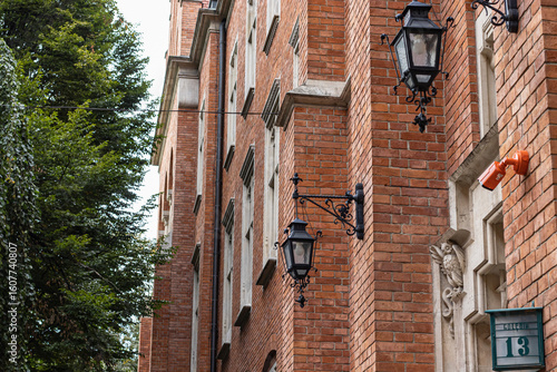Historic Brick Building Facade with Ornate Lamps and Number 13