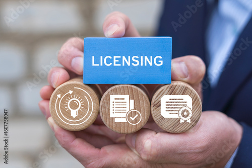 Foto Business person holding blocks with icons sees the word: LICENSING