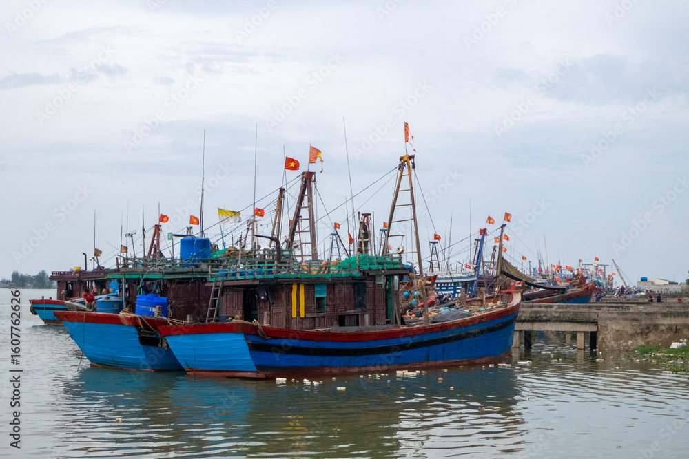 Obraz premium Trash-Littered Beach with Fishing Boats in Vietnam
