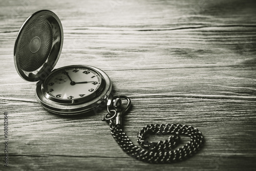 Εκτύπωση καμβά Vintage pocket watch on a wooden background, black and white photo