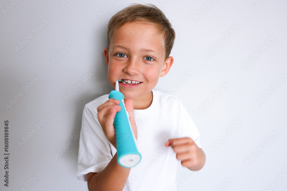 Cheerful young boy brushing teeth in bathroom. Morning hygiene routine, dental care and healthy habits for kids. Child smiling in front of the mirror with a toothbrush. Cheerful young boy brushing teeth in bathroom. Morning hygiene routine, dental care and healthy habits for kids. Child smiling in front of the mirror with a toothbrush.