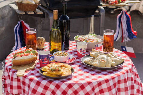 Chilean Independence Day: Independence Day celebration table with traditional empanadas, wine, chicha and patriotic decorations