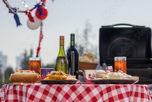 Chilean Independence Day: Traditional food table with completos, empanadas, sopaipillas, wine and chicha during Independence Day