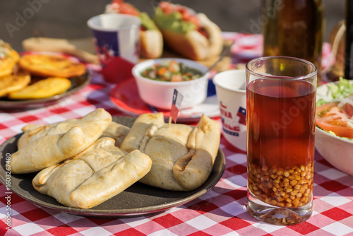 Chilean Independence Day: Close-up of empanadas, mote con huesillo and pebre on traditiona
