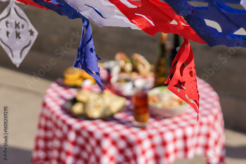 Chilean Independence Day: papel picado garland in foreground with traditional food table in background