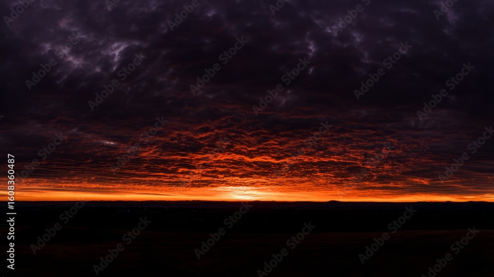 Fototapeta premium Dramatic sunrise with gradient orange and purple clouds, creating a panoramic abstract sky view. 