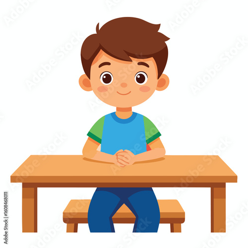 A young boy with brown hair sits at a wooden desk, smiling.
