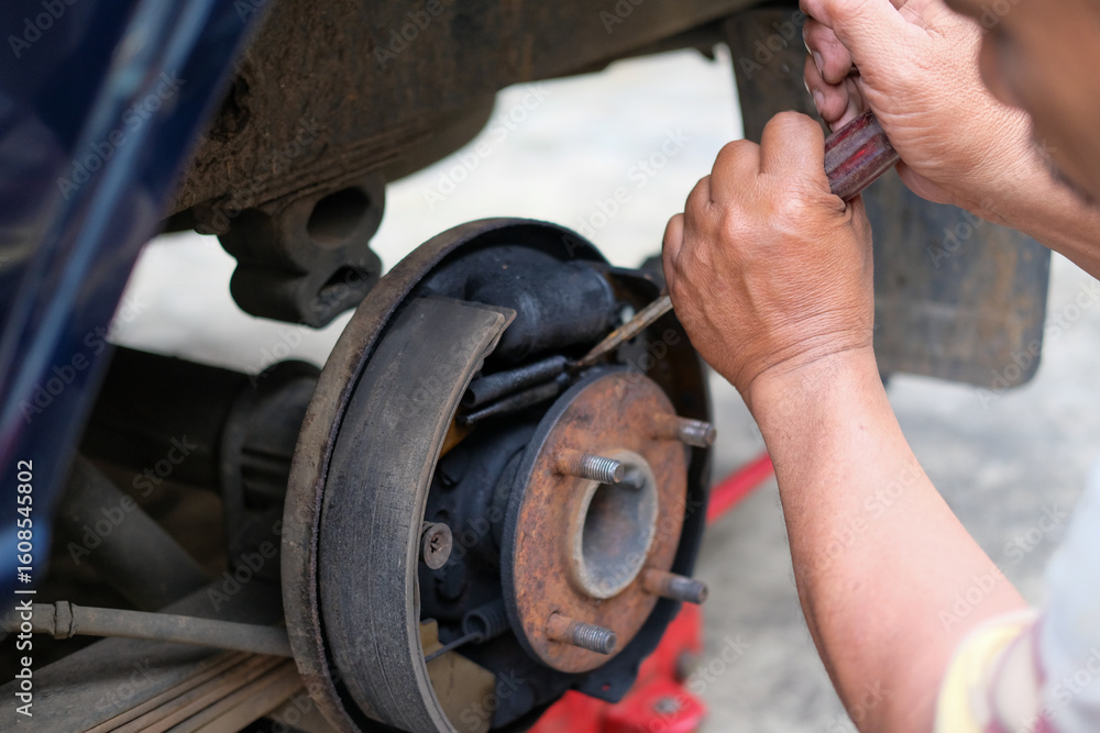 Fototapeta premium Mechanic working on vintage car brakes