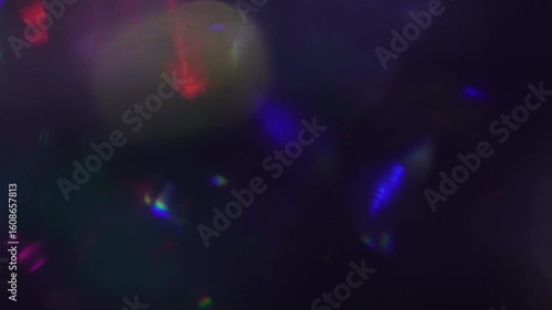 Magical abstract background with multi-colored red, blue, and purple bokeh lights and lens flares creating a festive and mysterious overlay effect