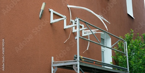 Wall mounts for heat pump on residential facade with scaffold