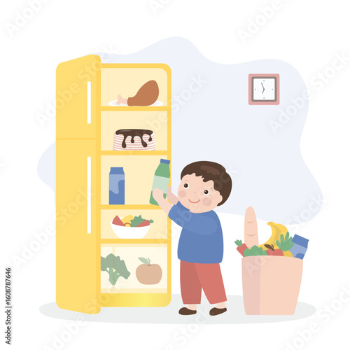 Open refrigerator with various fresh products. Cute child helps to unpack and put purchases in the refrigerator. Boy helper. Happy kid doing household chores