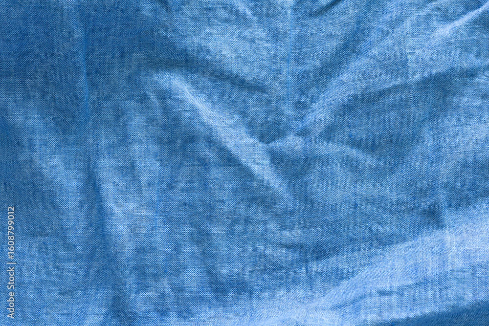 Naklejka premium A close-up of a textured, deep blue linen fabric with wavy. abstract background design.