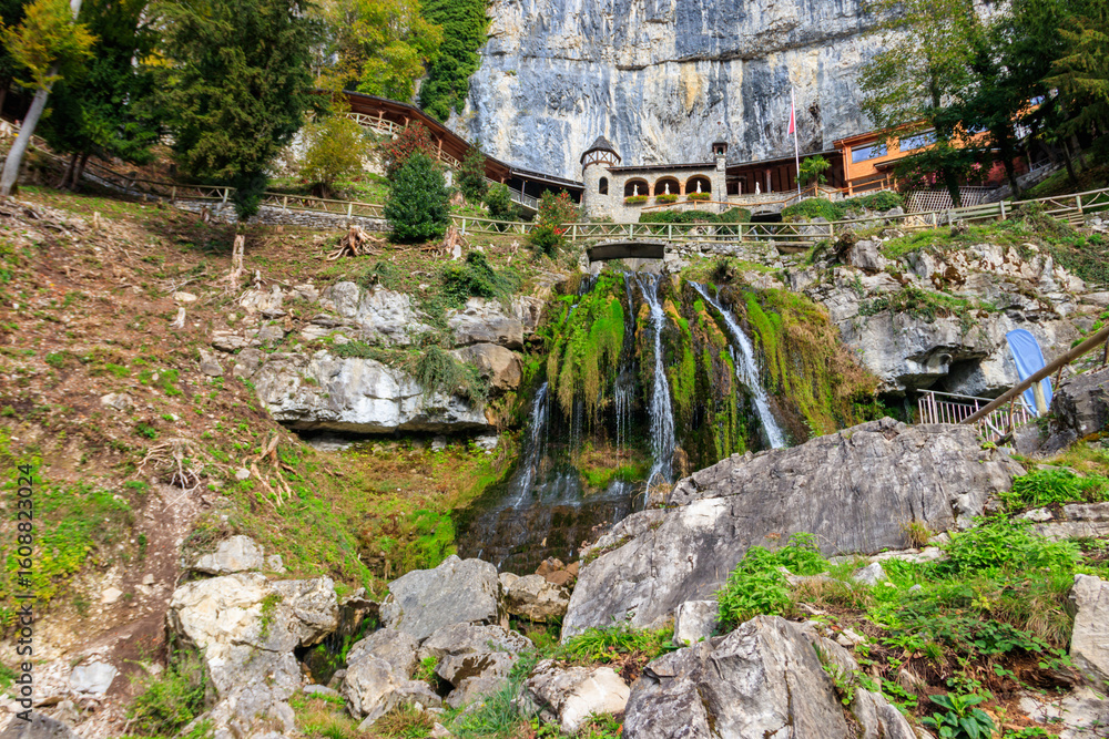 Fototapeta premium St. Beatus Waterfall at St. Beatus Caves entrance in Beatenberg, Bernese Oberland, Switzerland