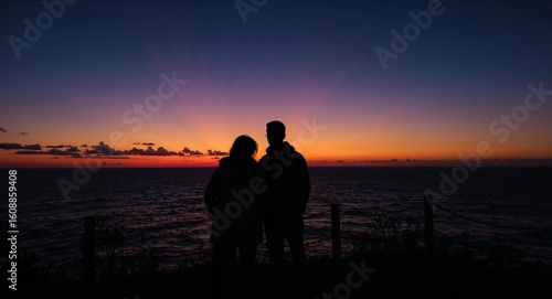 Silhouette Couple Gazing at a Breathtaking Sunset Over the Sea Horizon.