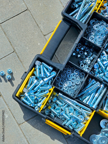 Toolbox full of bolts and nuts on the ground in the street