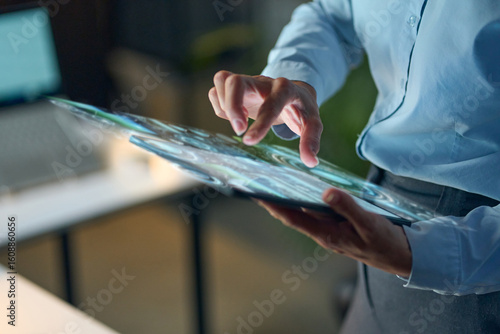 Professional Touches Futuristic Tablet Screen, Showcasing Advanced Technology, Innovative Interface, and Digital Interactions in Office Space, Representing Modern Business Solutions.