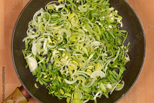 Fotografi A generous amount of freshly sliced green and white leeks is spread evenly in a