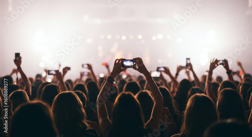 Crowd at a concert taking photos with cell phones.