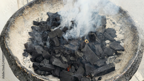 Wallpaper Mural Charcoal for cooking. Smoke rises from the burning charcoal in the stove. Smoke from charcoal on burning charcoal. Preparing the fire for cooking. Close-up of a pile of firewood. Torontodigital.ca