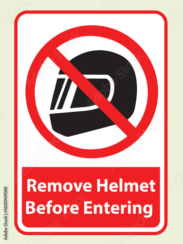A rectangular sign with a red border and a black helmet icon crossed out in red, instructing "Remove Helmet Before Entering".