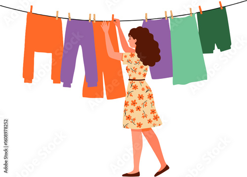 A woman hanging clothes on a clothesline.