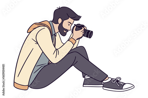 Focused male photographer capturing a moment with his digital camera while sitting down in casual attire