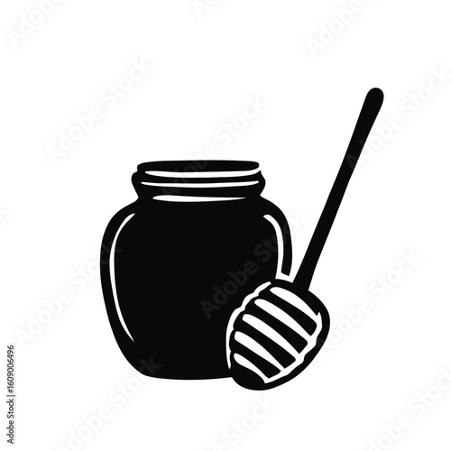 Glass jar of honey with a wooden dipper isolated on white