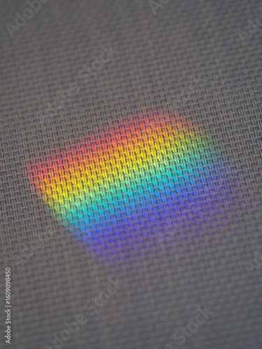A rainbow is reflected on a gray fabric