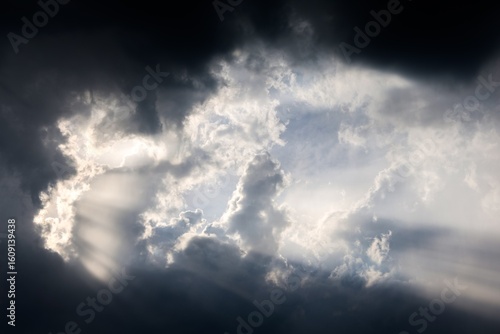 Tableau sur toile Sunbeams filtering through dark clouds illuminating the sky
