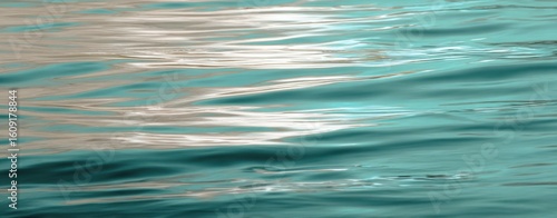 The tranquil water surface reflecting soft hues and gentle waves.