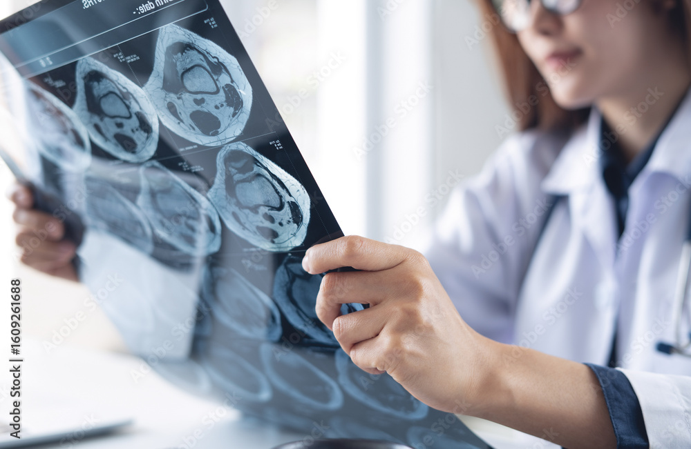 Φωτογραφία Asian orthopedics surgeon doctor examining patient's knee joint x-ray films, MRI bone, ct scan in radiology orthopedic unit in hospital