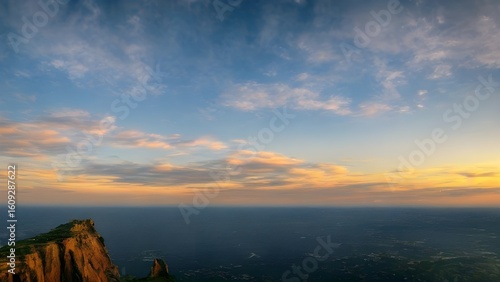 Golden hour paints a beautiful sky over the summer mountains, as the sun dips below the horizon